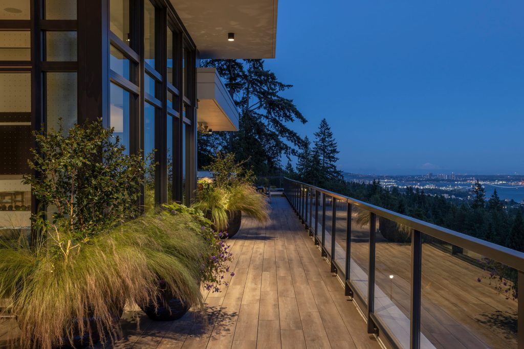 Swicks_3101_Burfield_Web-23-7136 - Swick's Landscaping Ltd. Modern balcony with glass railing and potted plants overlooking a city at dusk/sunset glow in distance?